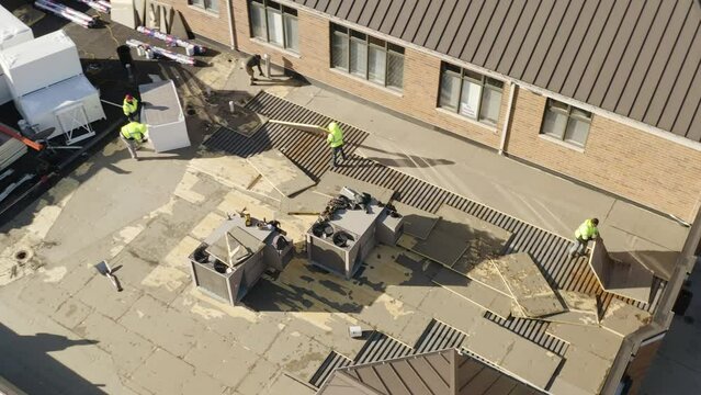 Roofing crew removing and replacing insulation on a flat roof