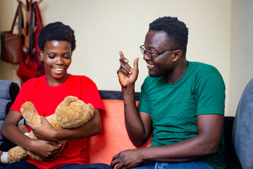 young african couple sitting together in sofa at home.