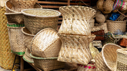 A pile of handmade traditional woven baskets made from straw, natural fiber, for sale at the outdoor market in Cuenca, Ecuador
