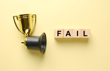 A picture of broken trophy with fail wooden block. Fail to win the game concept.
