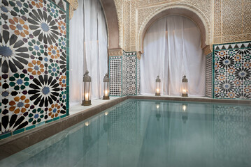Steamy hot water bath in Arab baths with candle lamps under semicircular arches - obrazy, fototapety, plakaty