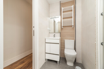 Fototapeta na wymiar Bathroom with mirror, white sink cabinet, white towel radiator and wc