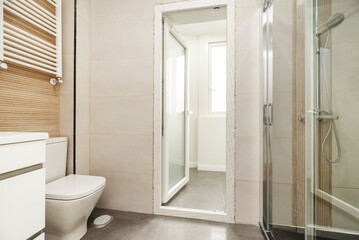 Fototapeta na wymiar White bathroom vanity unit, white towel rail radiator, wc, shower with glass partition and exit to clothesline