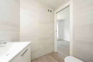 recently renovated bathroom with imitation marble tiles, wooden flooring and white wooden sink cabinet and china