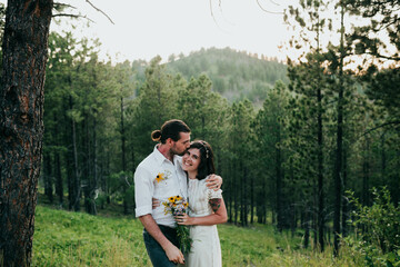 Husband and wife embrace in the black hills national forest