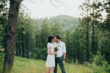 Husband and wife embrace in the black hills national forest