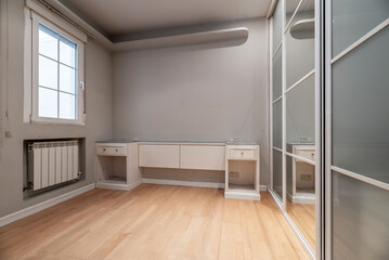 Bedroom with wooden headboard and side tables and built-in wardrobe with glass doors and wooden flooring