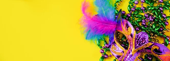 Gordijnen Carnival mask with feathers on yellow background. Multicolored beads Mardi Gras or Fat Tuesday symbol. © Galina Atroshchenko