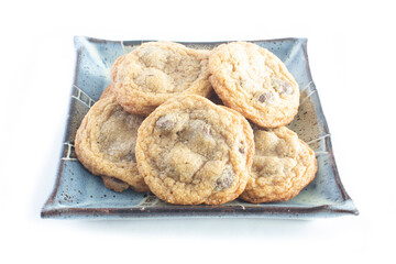 Plate of Chocolate Chip Cookies are that Fresh and Homemade on Square Pottery Dish Isolated on White