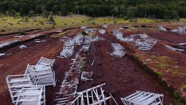 Aerial view of an abandoned peat extraction factory in the Andes mountains. View of the red peat land, forest and mountains.