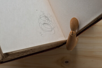 old book with scribble and mannequin hand and arm