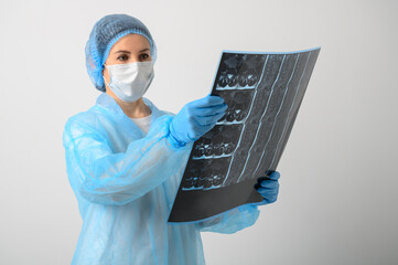 a nurse in a medical gown, mask and protective gloves