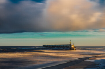 Sunrise Baltic Sea Mielno with colorful storm clouds breakwater long exposure