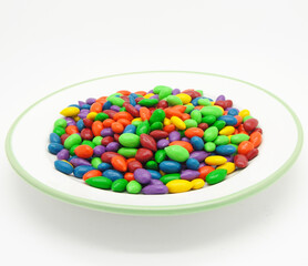 Chocolate Covered or Coated Sunflower Seeds Isolated on White in Saucer with Green Rim