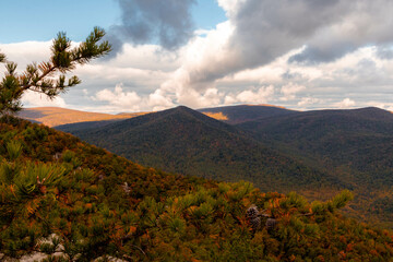 View of Mountains with Autumn Foliage Trees with a Cloudy Blue Sky