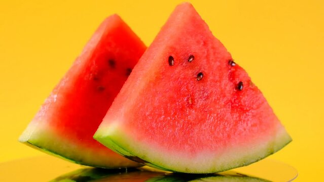 watermelon in a cut. Slices of watermelon on a yellow background. Rotation. Ripe Appetizing summer fruits. 4k footage