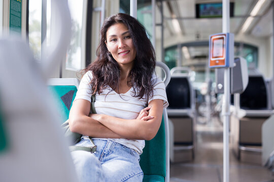 Oriental woman sitting on her seat in tram and waiting for next stop.