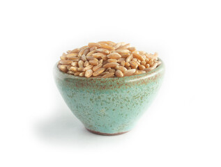Ancient Emmer Wheat or Farro Berries or Grains in Green Pottery Bowl Isolated on White