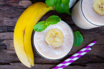 Banana fresh cocktail vanilla smoothies  fruit juice beverage healthy the taste yummy in glass drink episode good morning on wooden background from the top view.