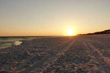 Sunset on the beach with tire tracks