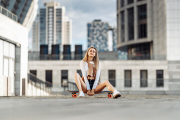 Sexy girl sitting on a skateboard.