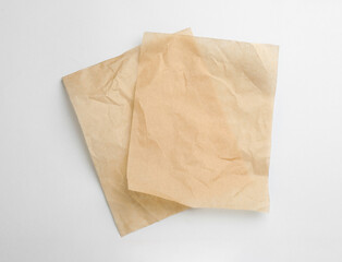 Sheets of brown baking paper on white background, top view