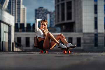 Sexy girl sitting on a skateboard.
