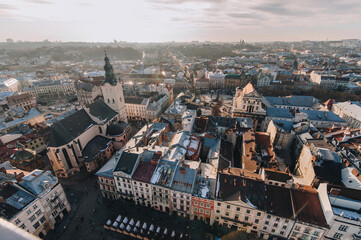 View of the old city from above, from the observation tower of the town hall. Roofs of houses in the evening. Ukraine, Lviv Cathedral, winter panorama.