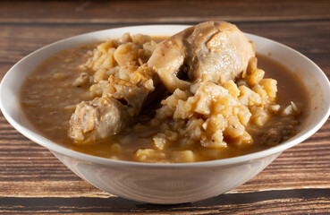 Chicken carapulcra on a plate on a wooden background