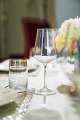 wine glass and beverage glasson served dining table with utensils and flowers