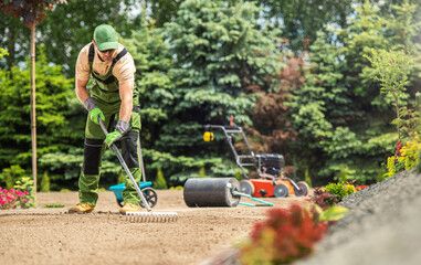 Garden Specialist Preparing Soil For Grass Turfs Installation