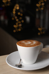 Cup of aromatic coffee on wooden table in cafe, space for text