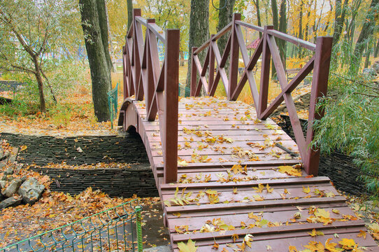  Wooden bridge in the park area. Wooden bridge over the pond.
  Wooden bridge in the park landscape. 
