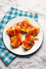 Orange halves with chili pepper powder and chamoy on white background