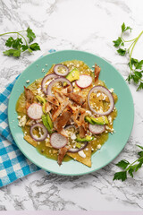 Green chilaquiles with pork meat and cheese. Mexican food
