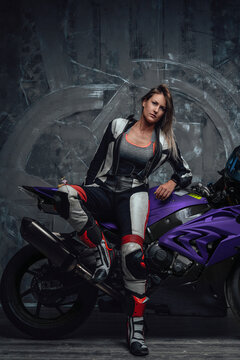 Serious woman biker dressed in professional motorcycle suit