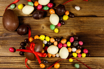 Easter composition with chocolate eggs on wooden background