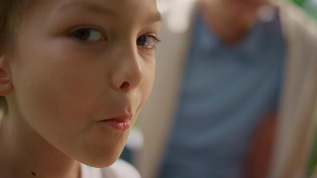 Cute Boy Eating Coockies Looking On Camera Close Up. Portrait Of Munching Child.