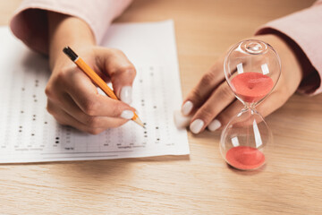 writing a test in a short time. Students hands to take exams, write an examination room with a pencil holding on the optical form of a standardized test with answers 