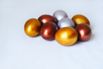 Festive Easter eggs in golden and silver colors on a white background.