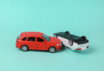 Two mini toy car crash on blue background, incident, car traffic accident
