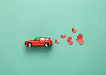 Romantic, love concept. Car model with hearts on a blue background/ Top view