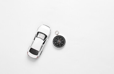 Toy car with compass on white background. Travel concept. Top view
