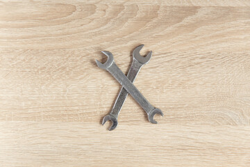 Metallic wrenches on a wooden table. Top view