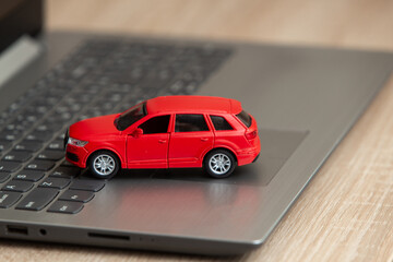 Toy car model on laptop on table