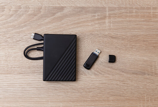 External hard drive with USB stick on wooden table
