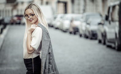 Portrait of a business woman in the city. Young blonde girl in business clothes