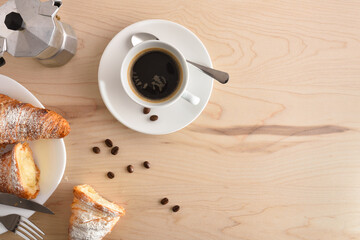 Beakfast table with cup of coffee beans and pastries top