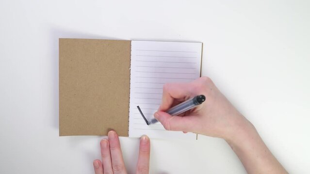 No write text top view. Rejection letters. A hand writes a note in a notebook with a pen and tears out a sheet. Crumple the paper into a fist. flat lay white table in office.