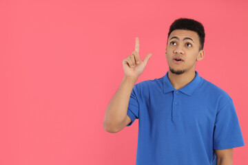 Young man in blue polo on pink background